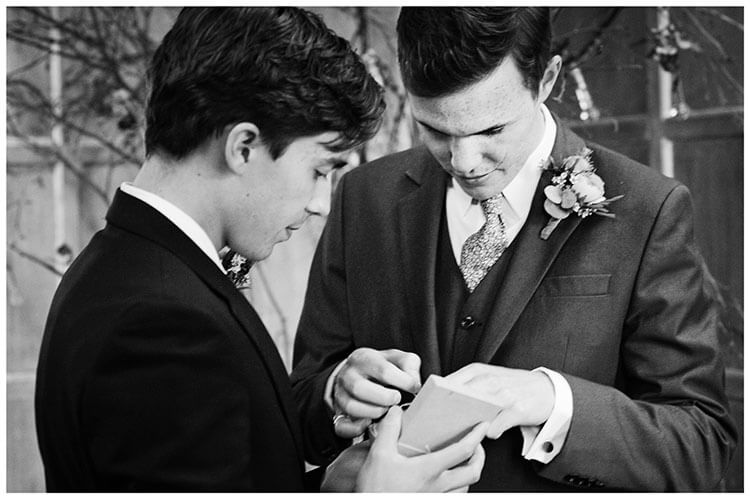 groom checking wedding rings with best man