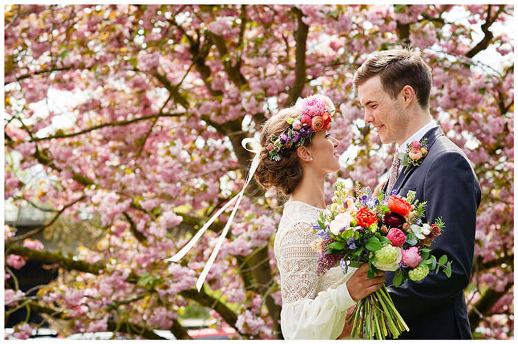 bride groom infront of blossom tree at old bridge hotel