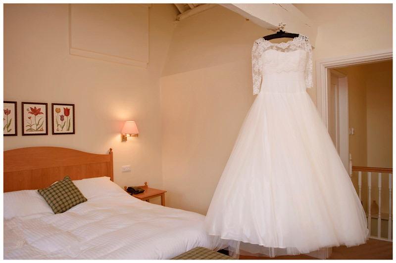 wedding dress hung from bedroom beams