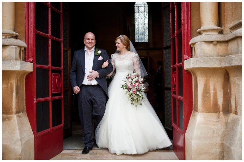 smiling bride and groom leaving Woburn Abbey after ceremony