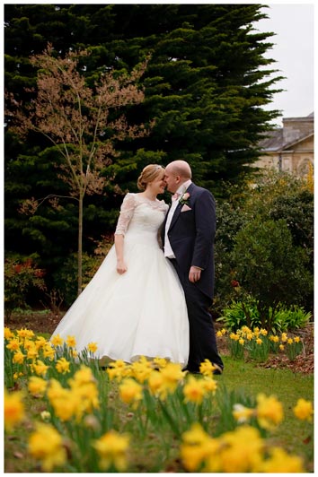 woburn sculpture gallery gardens full of romantic daffodils bride groom kissing in background