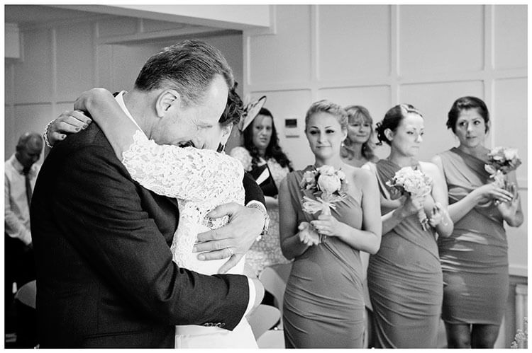 Old Bridge Hotel Huntingdon wedding bride hugs groom brides maids look on