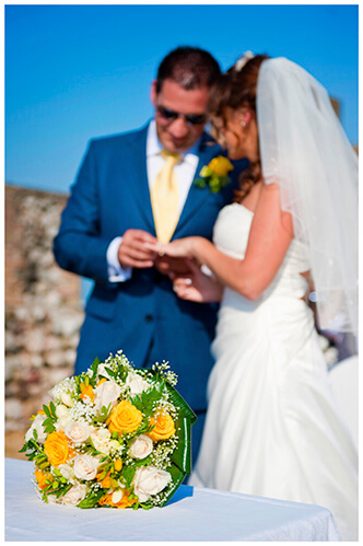 lake garda wedding photography bridal bouquet groom placing ring on brides finger in background