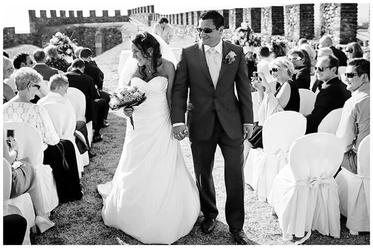 lake garda wedding photography smiling bride walking down aisle with groom in sunglasses