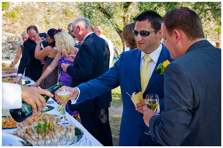 lake garda wedding photography groom talking to guest getting drink