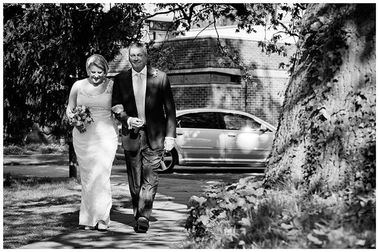 churchill college wedding bride walking to church on father arms
