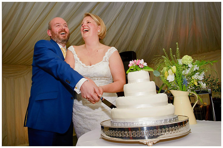 churchill college wedding cake cutting bride groom laughing