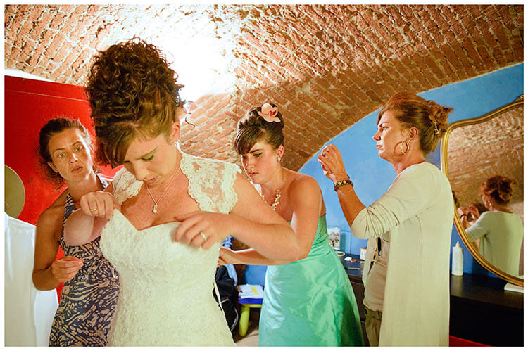 Castel di Poggio wedding bride getting into dress
