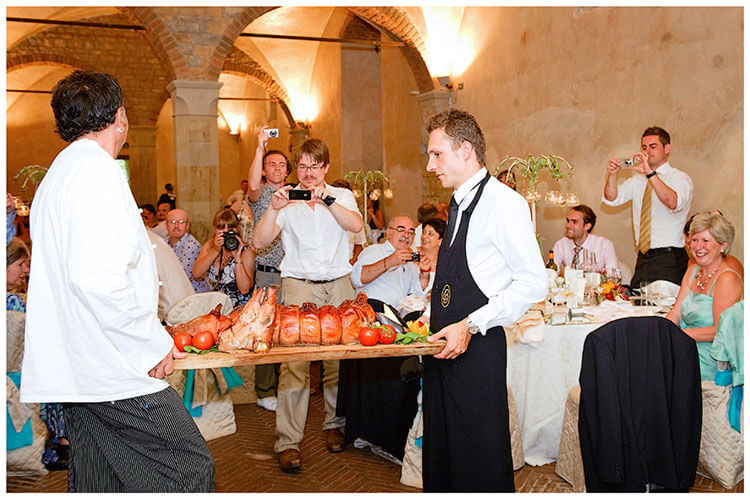 Castel di Poggio wedding taking photos of suckling pig for dinner