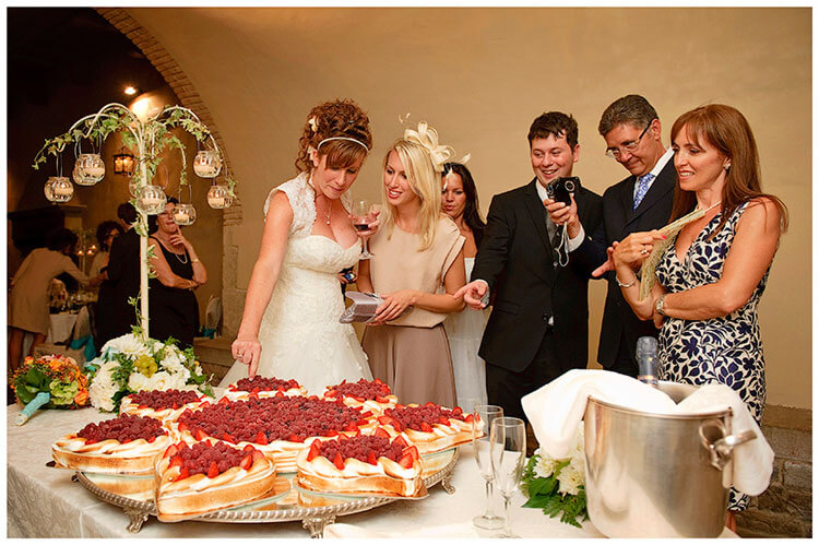 Castel di Poggio wedding bride picks a fruit from the spectacular wedding cake