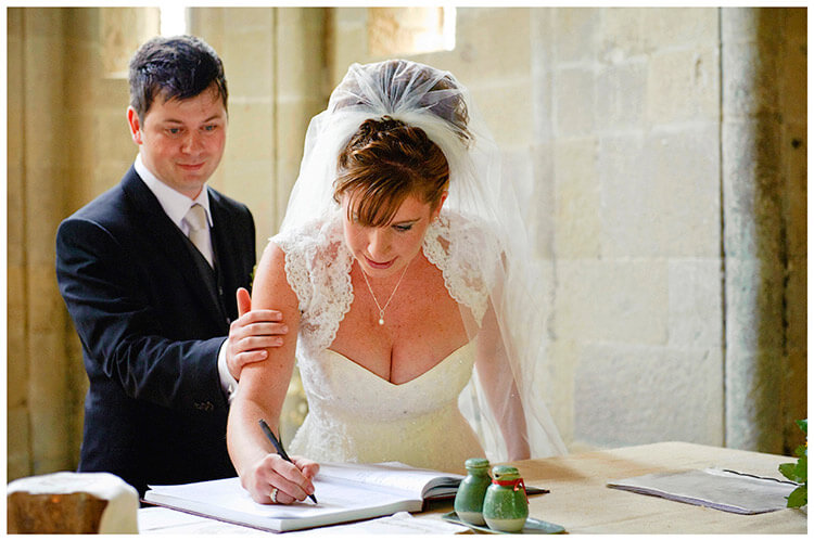 Fraternita di Romena wedding resuring hand from groom as bride signs register