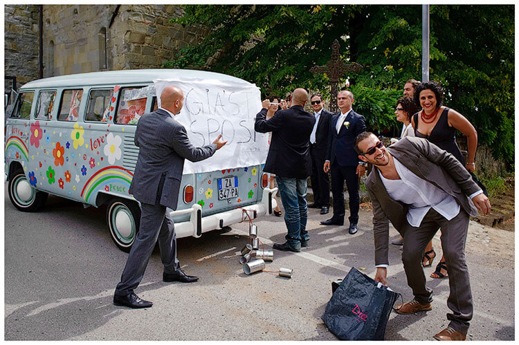 Fraternita di Romena wedding guests tying sign to back of blue VW Camper