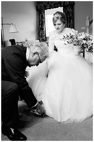 Woburn wedding brides father places shoe on her foot