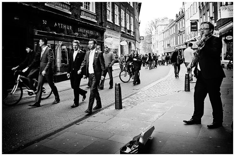 Christ’s College wedding groom and groomsmen walking through streets of cambridge musician