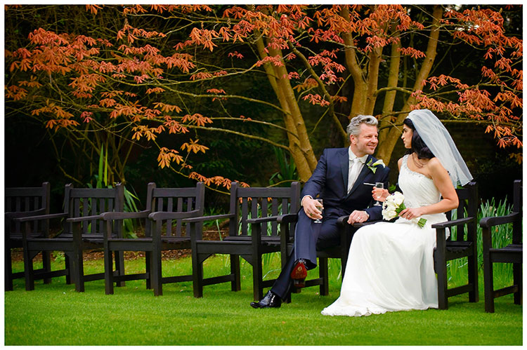 Christ’s College wedding bride groom sitting on bench colorful foliage in background