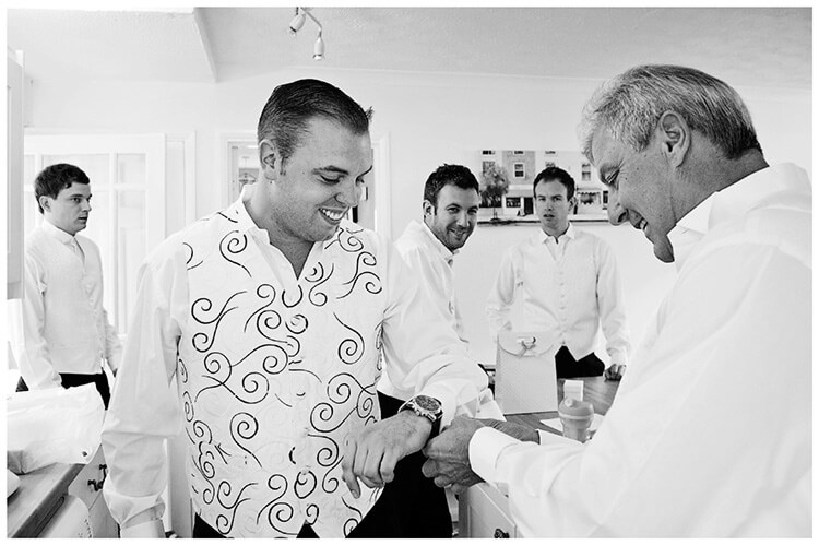 Wedding Photography at Tattersalls ushers watch as groom has cuff links fitted by father