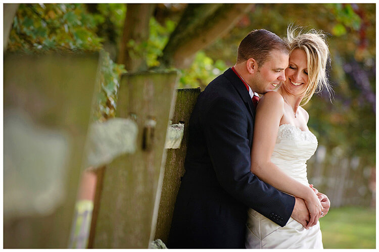 Wedding Photography at Tattersalls bride groom embrace leaning against fence