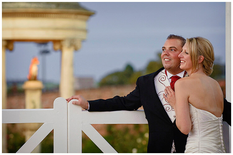 Wedding Photography at Tattersalls late evening bride groom embrace next to gate
