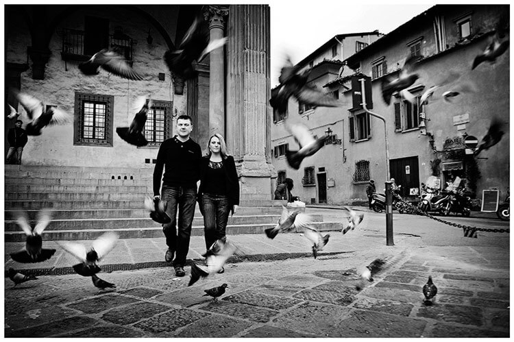 Pre-Wedding Photography in Florence couple walking through pigeons in flight