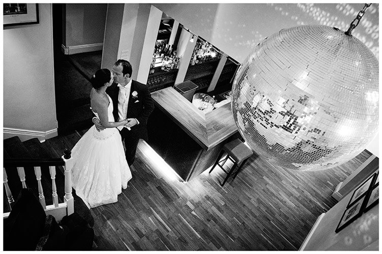 The Old Bridge Hotel wedding bride groom embrace in the bar beneath glitter ball