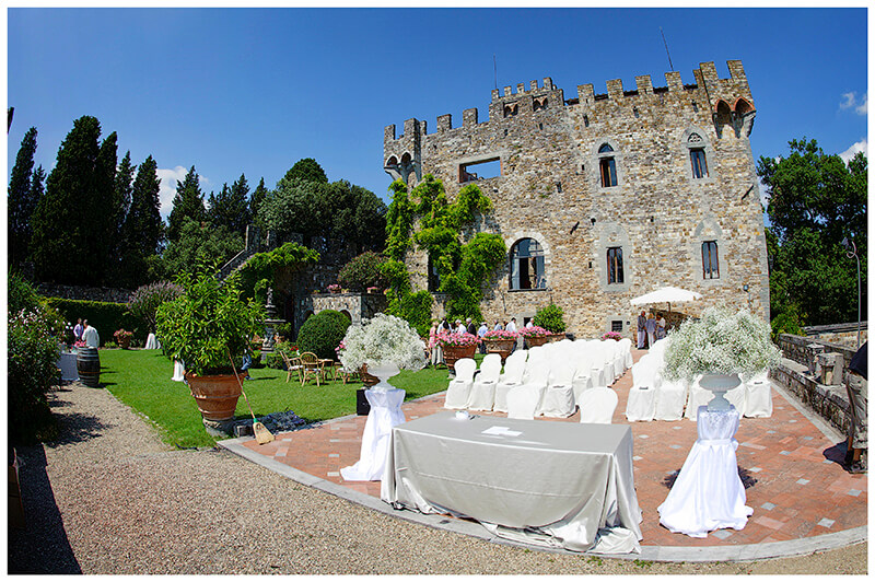 Castello di Vincigliata wedding venue set out for a wedding on patio under deep blue sky