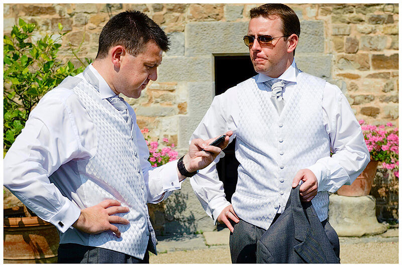 groom checks phone whilst standing next to bestman
