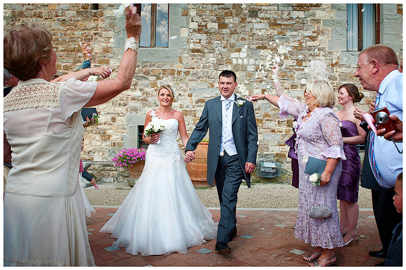 confetti and bridal couple with castello di Vincigliata in background