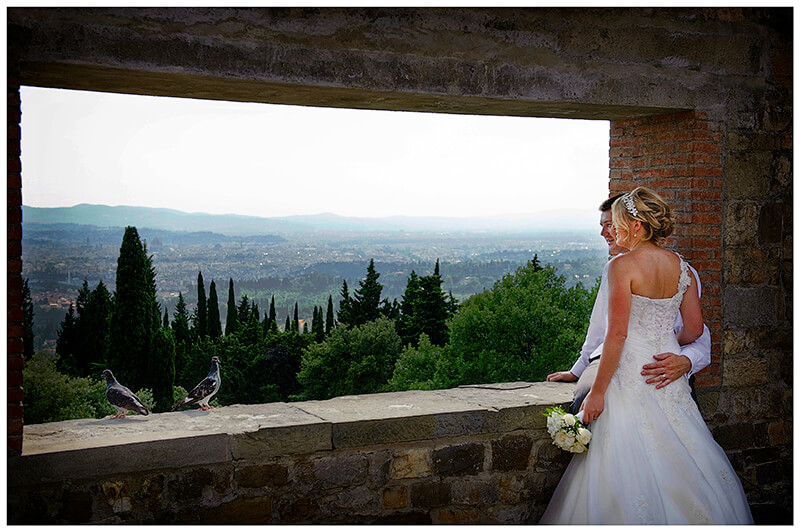  two pigeons join bridal couple in Castello di Vincigliata tower over looking Florence