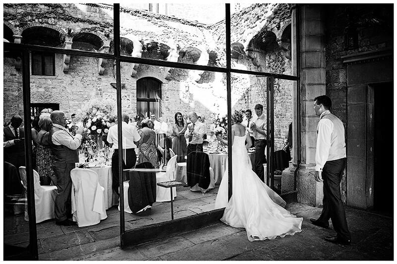 bride groom enter central courtyard of Castello di Vincigliata for meal greeted by guests