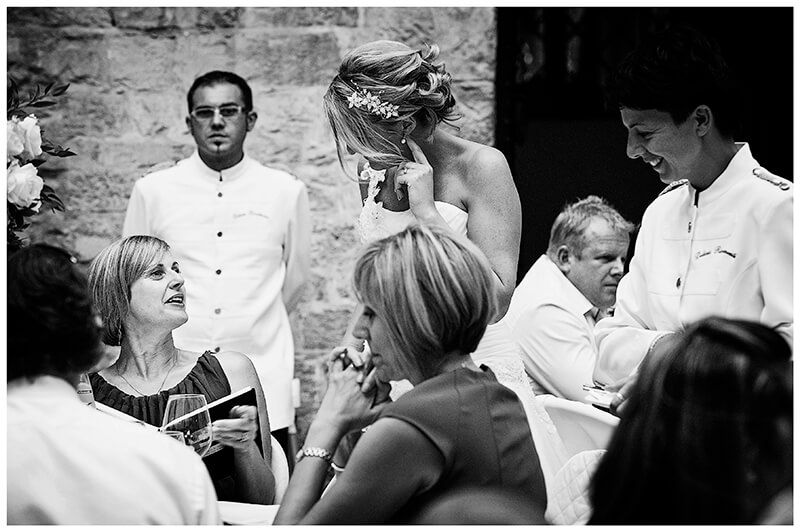 Castello di Vincigliata wedding photography guests talking to bride as waiters stand by