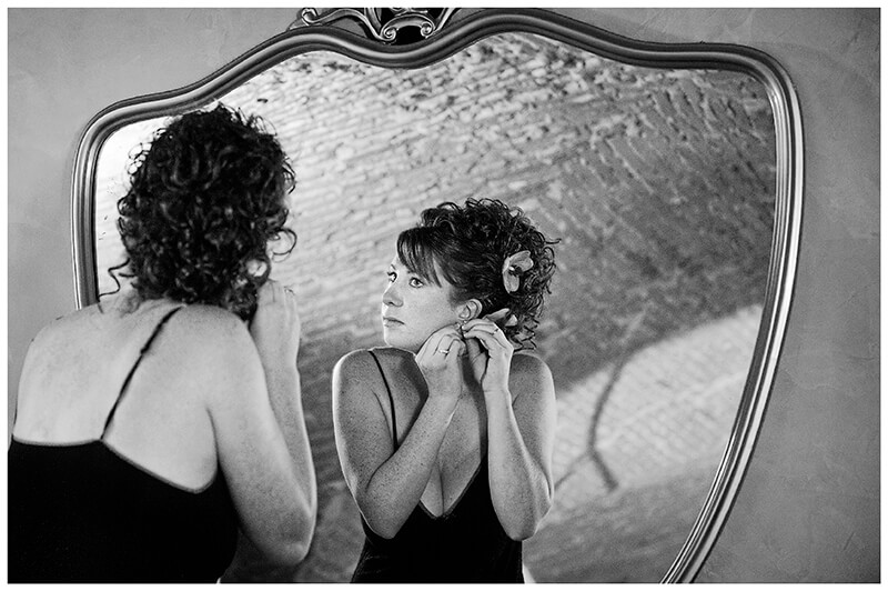  bride fitting earring reflected in ornate mirror