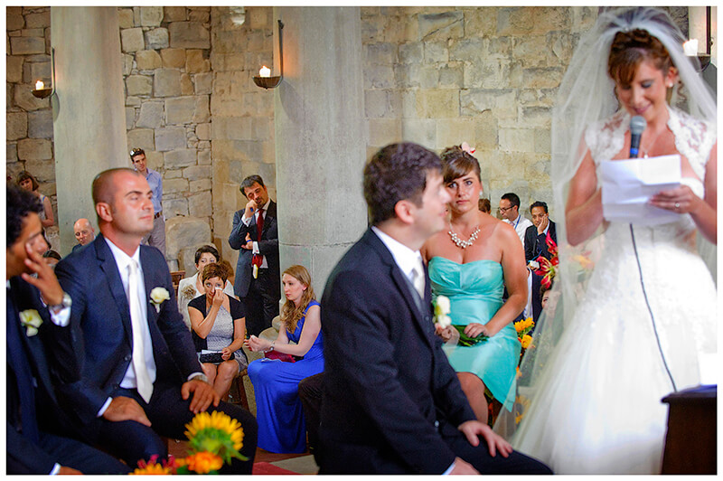 guests crying in background as Bride gives reading to groom Fraternita di Romena Tuscany 