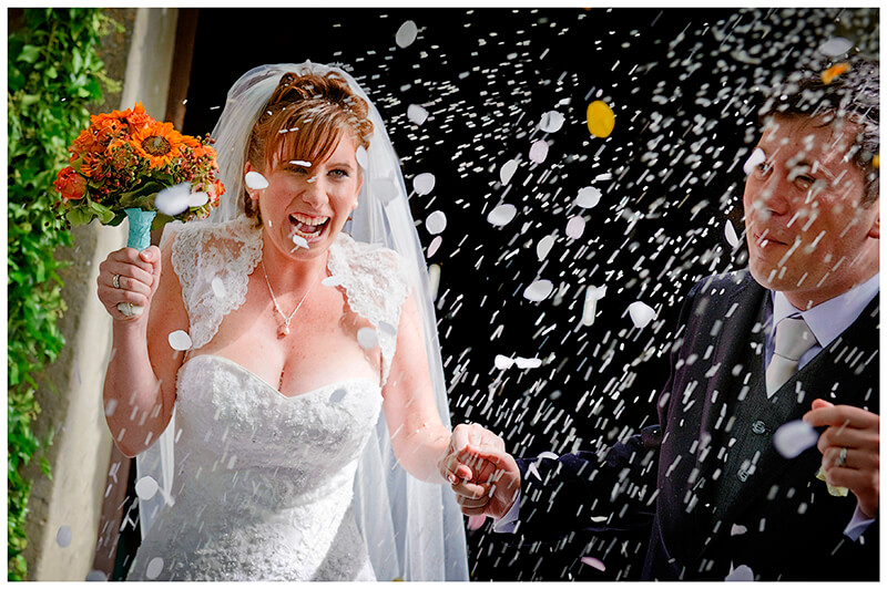 smiling bride during confetti throwing Fraternita di Romena Church Tuscany Wedding Photography