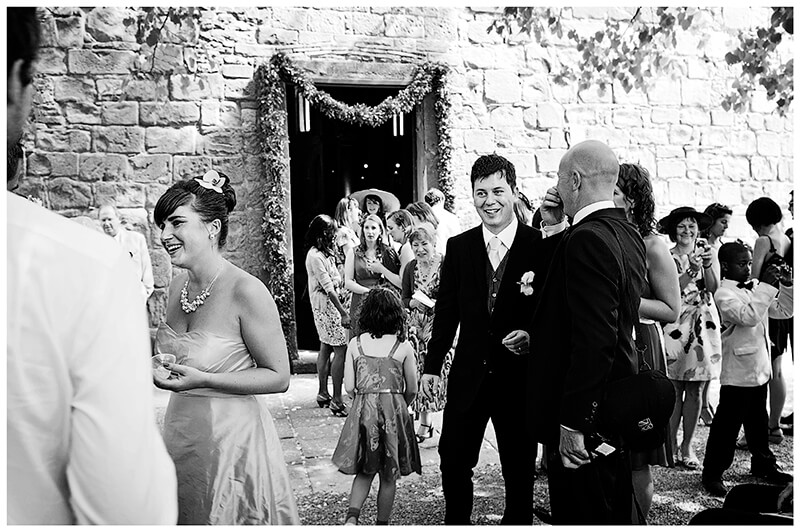 groom outside church with guests Fraternita di Romena Tuscany 