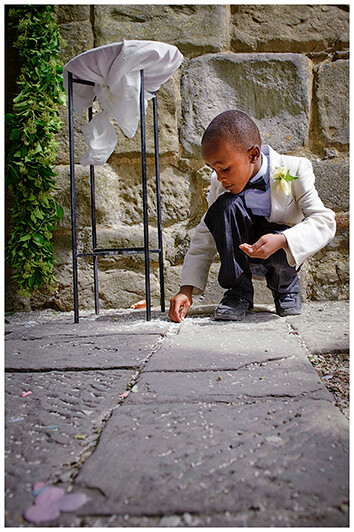 young guests picking up confetti rice from ground at Fraternita di Romena church Tuscany 