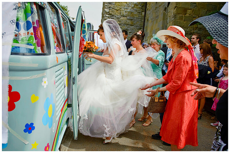 bride being helped in to the wedding VW Camper 