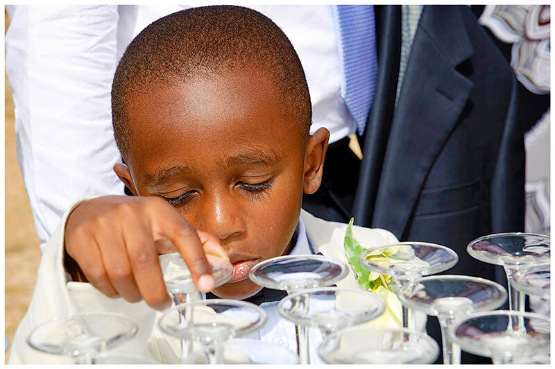 little boy playing with wine glass
