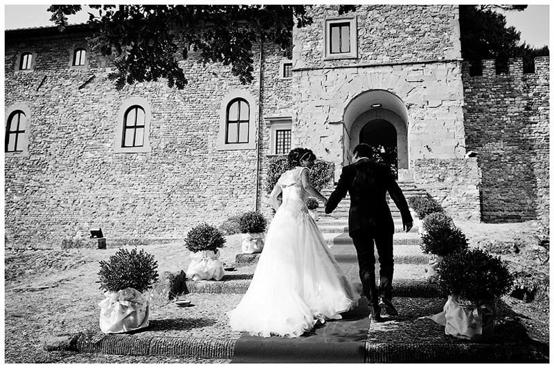 Bride and groom walking up red carpet to Castel di Poggio Tuscany Wedding venue