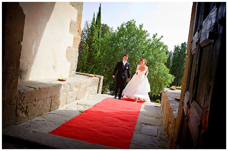 Bride groom on red carpet walking towards enterance to Castel di Poggio Tuscany Wedding venue