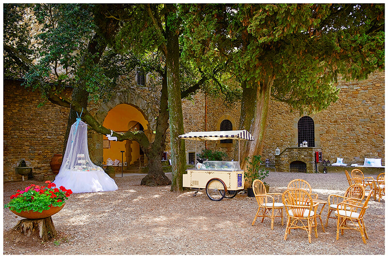 Sweet table and Ice cream trolly in Central courtyard of Castel di Poggio Tuscany Wedding venue