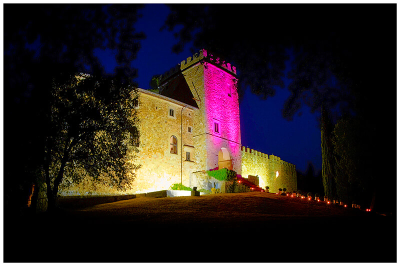 Castel di Poggio Tuscany Wedding venue at night lit with pink light