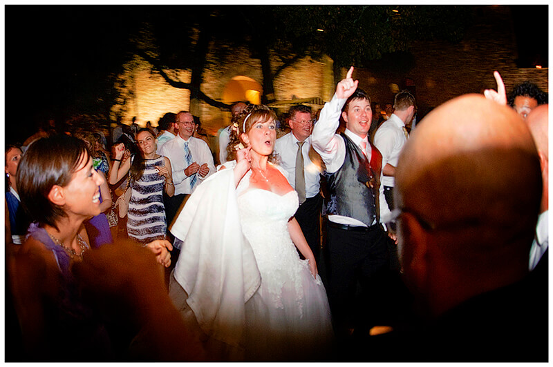 bride and groom enjoying dancing with guests under tuscany night sky