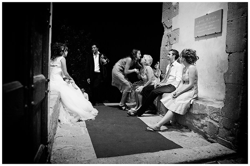 Bride and family say good night to guests sitting in entrance to Castel di Poggio Tuscany Wedding venue