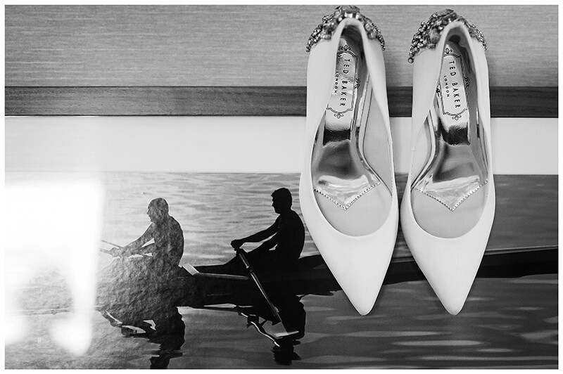 brides shoes hung on picture of rowers
