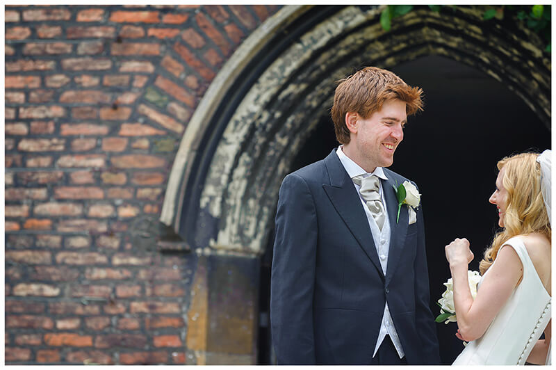 Groom smiles at his bride as she laughs 