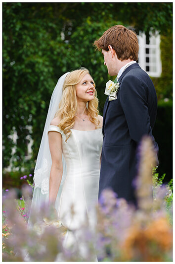 loving moment between bride and groom in the grounds of Newnham College Cambridge