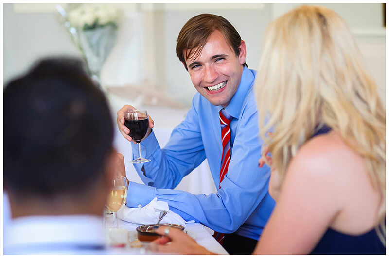 smiling guests with red wine in hand