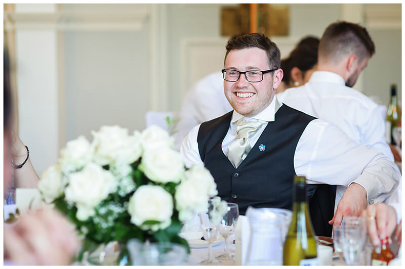 smiling groomsman at dining table Newnham College Cambridge