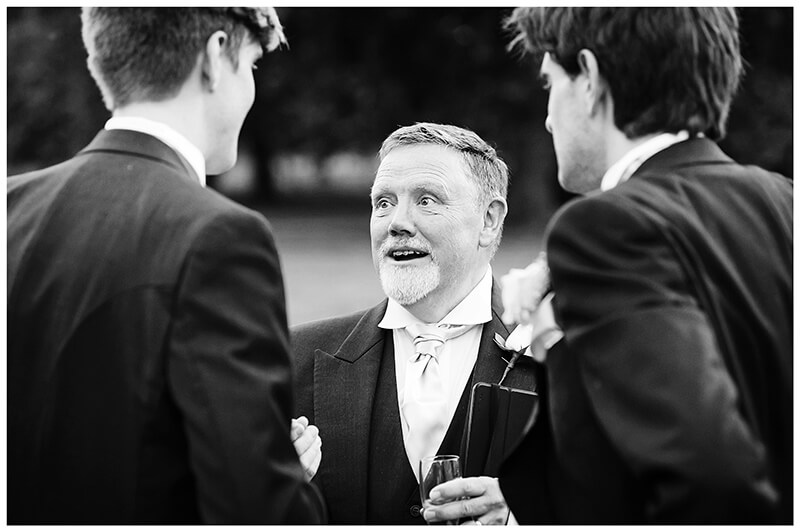 father bride talking to best man and groom