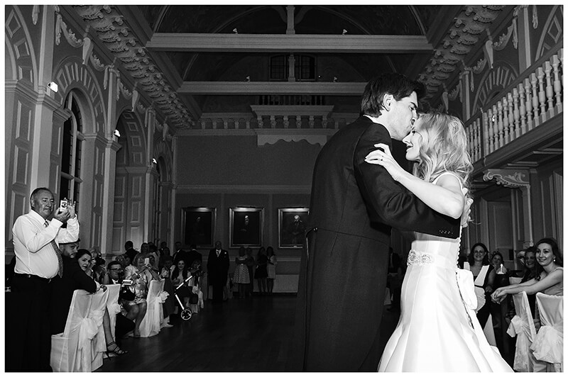 groom kisses bride on forehead during first dance 